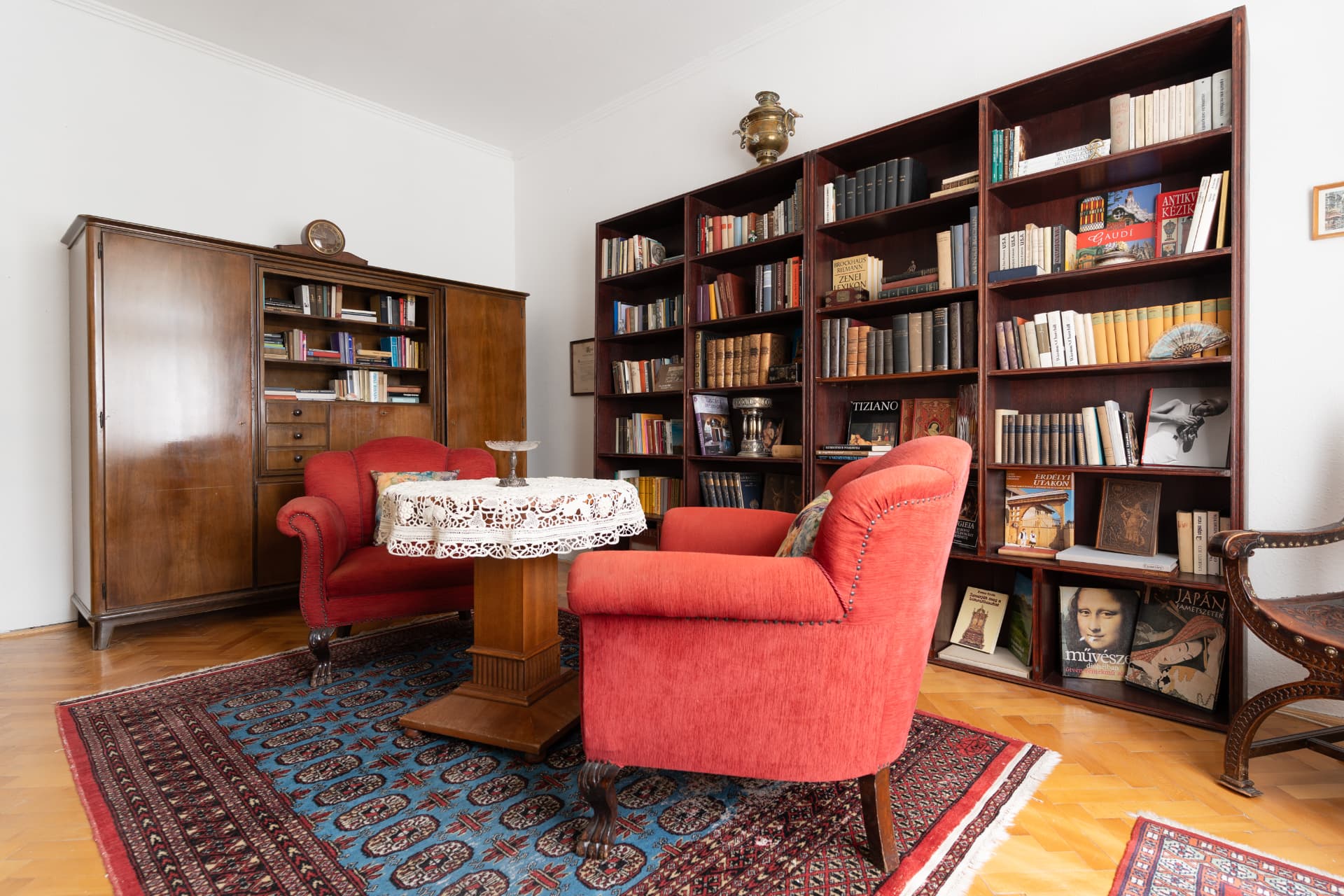 Reading corner with bookshelves and red armchairs