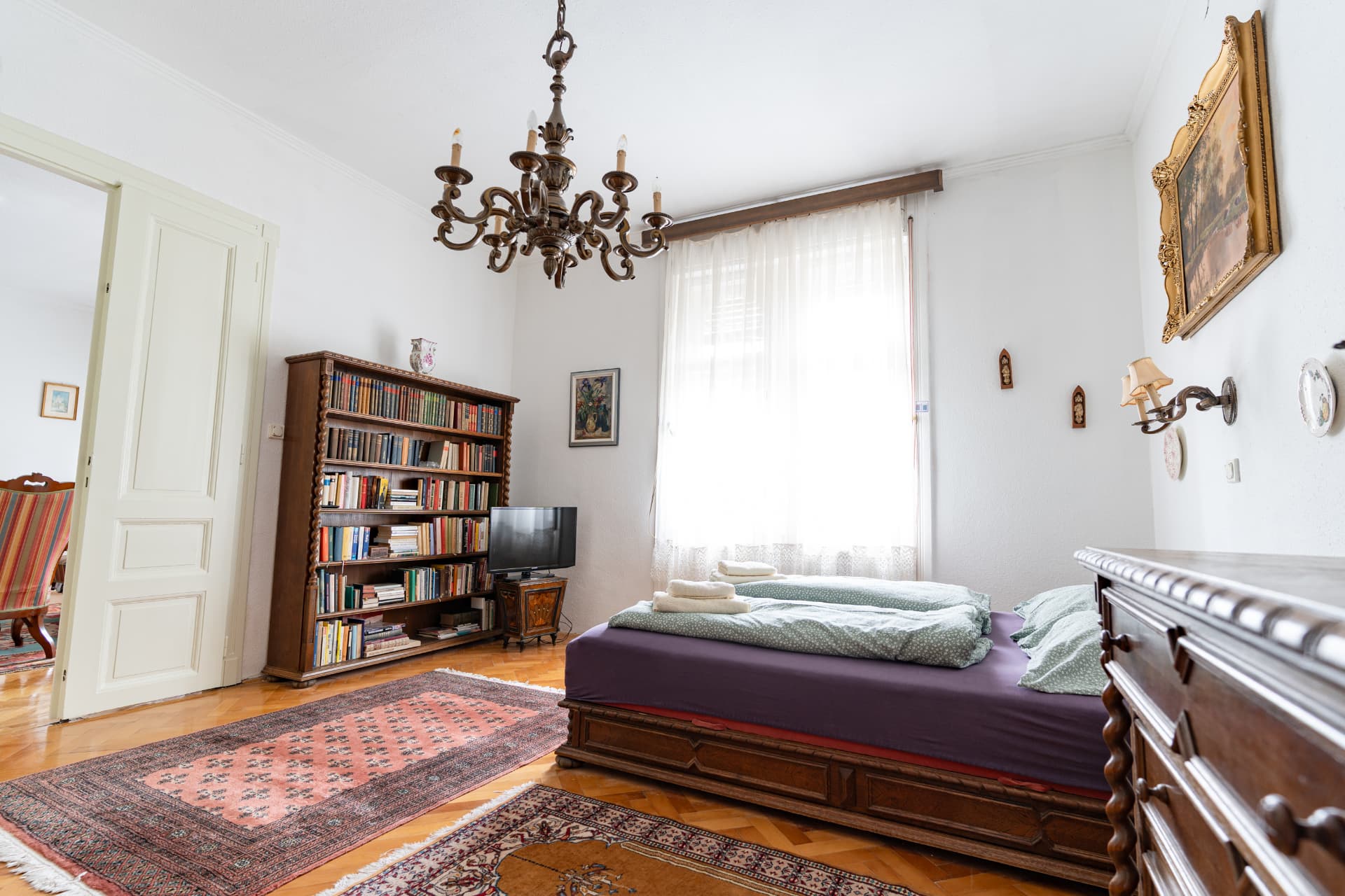 Double bedroom with a chandelier and bookshelves