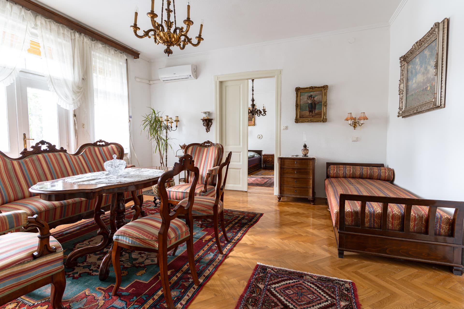 Antique sofa and daybed in the salon, with a view into the adjoining room
