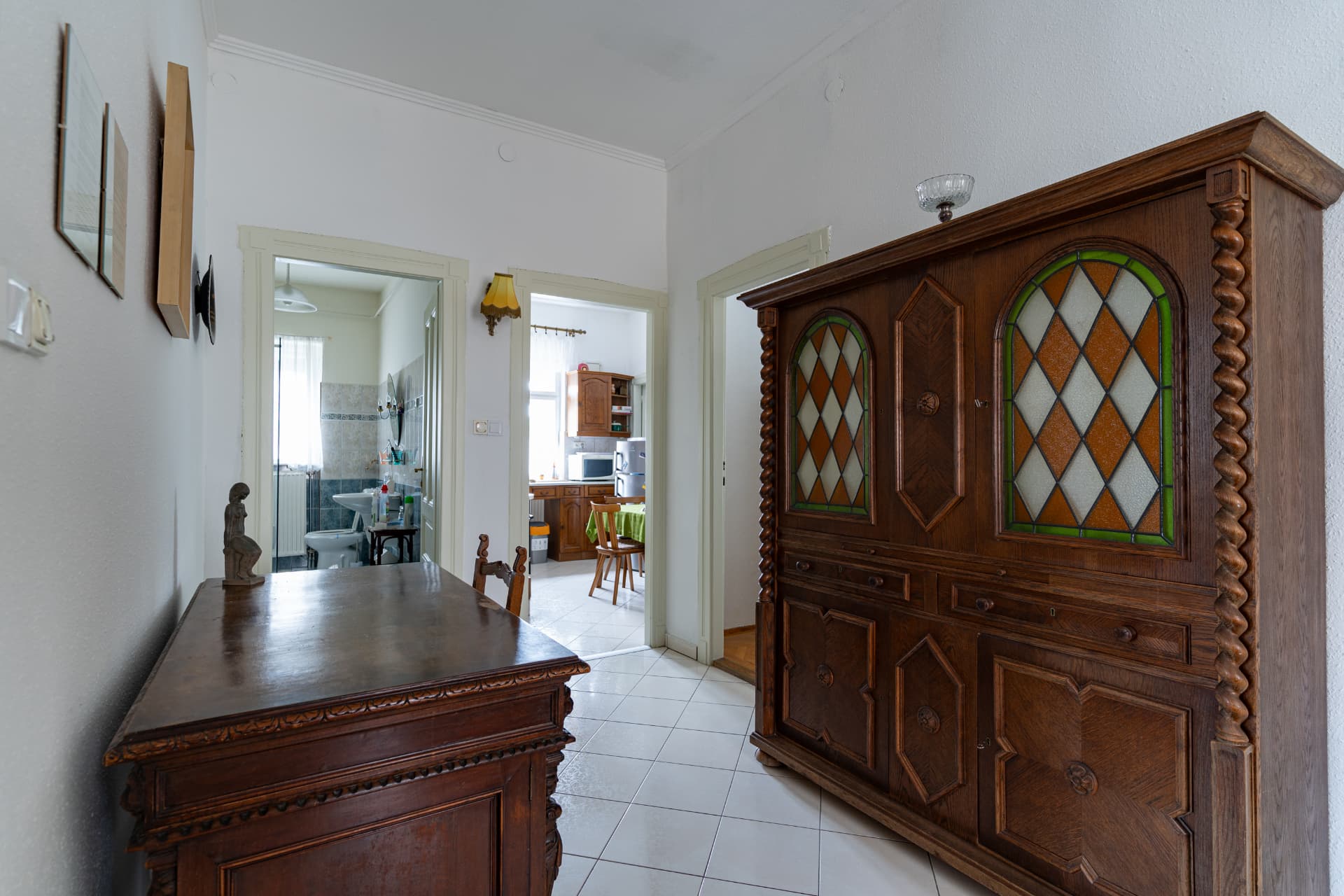 The apartment hallway with an antique glass-fronted cabinet